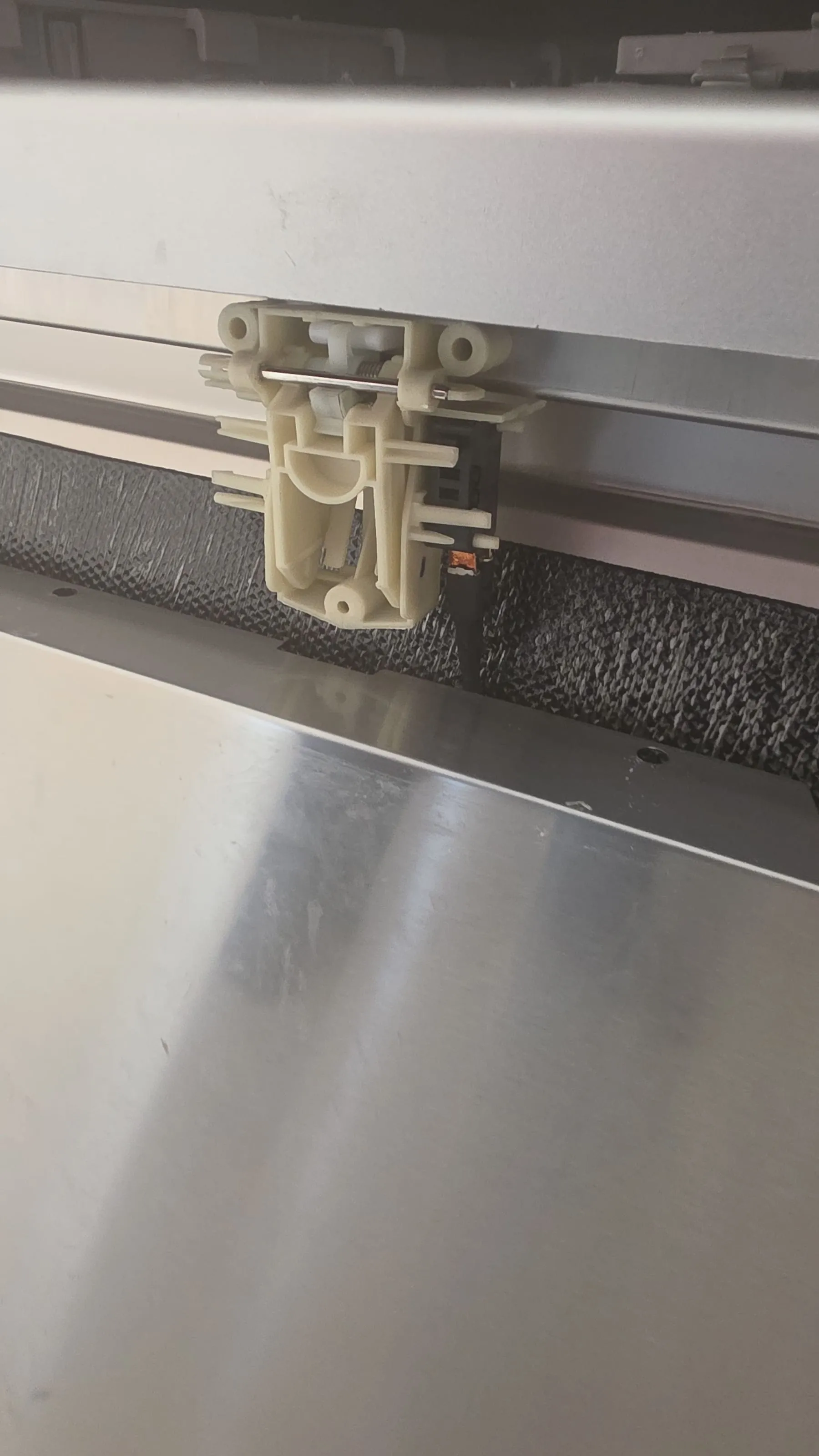 The dishwasher door latch with its small switch on the right-hand side