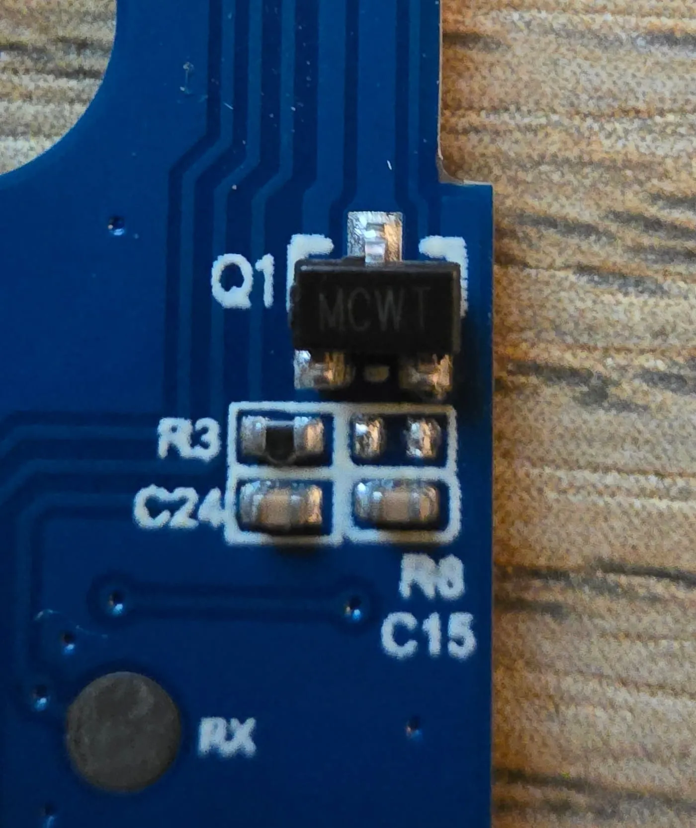 Close-up of a three-legged surface-mount chip marked MCWT, labelled Q1, at the edge of the door sensor board